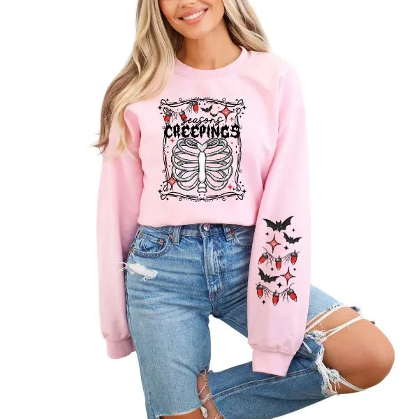 Pink 'Seasons Creepin' Sweatshirt with Skeleton Rib Cage, Christmas Lights, & Halloween Bats | Edgy Alt Vibe with Festive Sleeve Graphics | Perfect Blend of Halloween & Christmas | Cozy & Stylish | Available in Sizes Up to 4X | Unique Holiday Sweatshirt